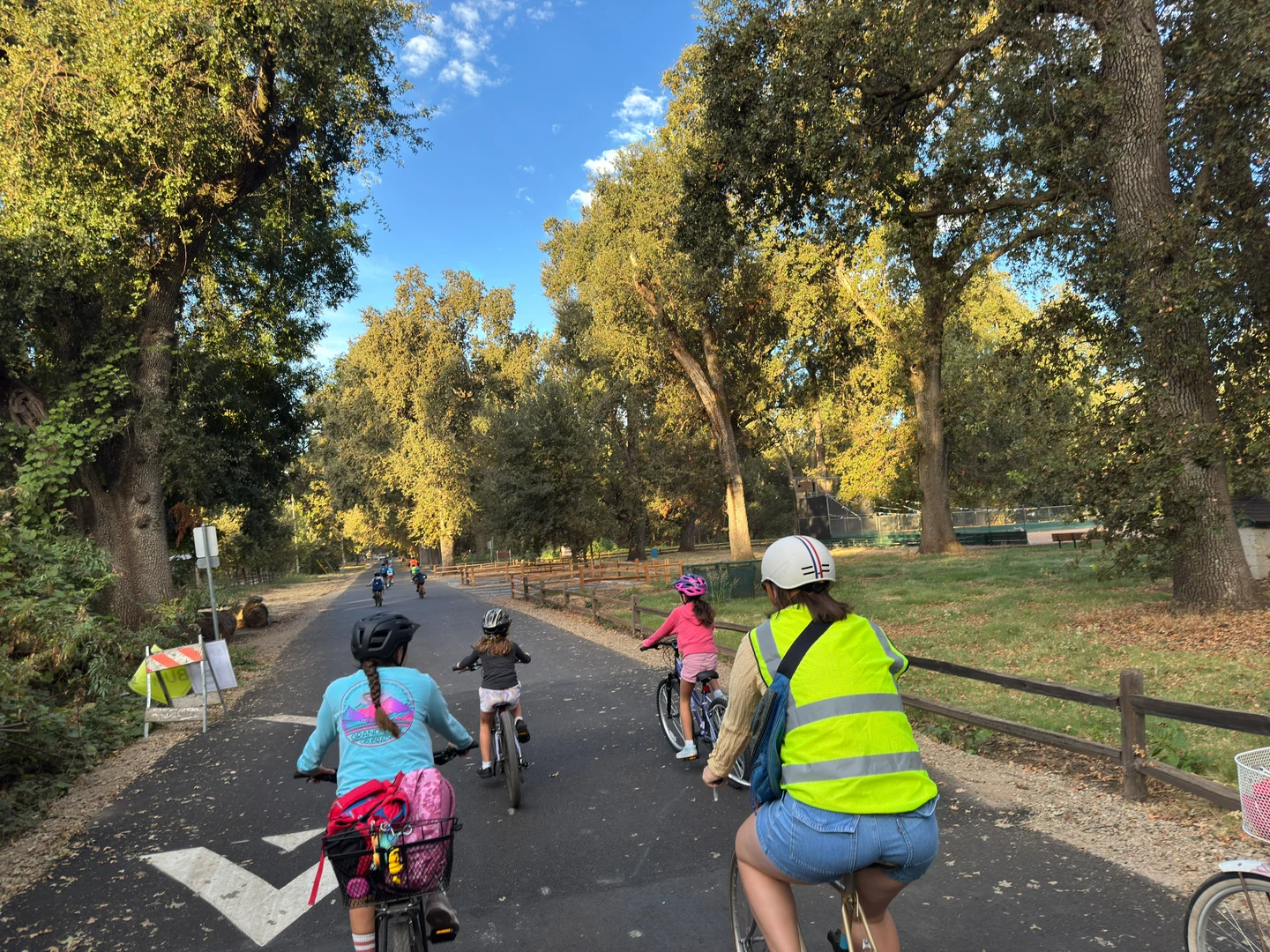 A group of riders following path markings through a leafy park